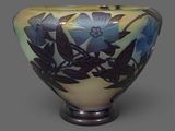 a vase with blue flowers painted on it on a gray surface