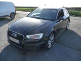 L'Audi noire est garée sur le parking, à côté d'une camionnette.