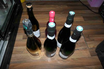 plusieurs bouteilles de vin sont alignées sur une table en bois