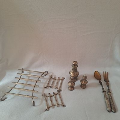 beaucoup d'argenterie sur une table à fond blanc