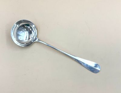 une cuillère posée sur une table, dans laquelle se trouve une autre cuillère