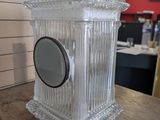 a clear glass clock sitting on a table in a room