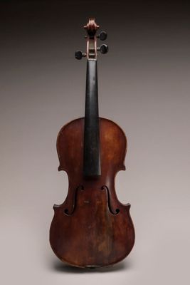un vieux violon posé sur une table près d'un mur