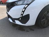the front end of a white car with black trims parked in a parking lot
