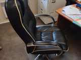 a black office chair sitting in front of a computer desk