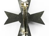 a metal pin with a star on it on a white surface