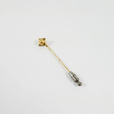 un gros plan d'une broche en or et en argent ornée d'une fleur