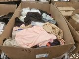 une boîte pleine de vêtements posée sur le sol