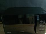 un four à micro-ondes noir posé sur une table en bois