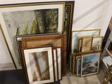 many framed and unframed art pieces on the floor