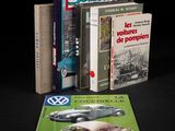 plusieurs livres posés sur une table noire, avec une Coccinelle VW et une Coccinelle VW