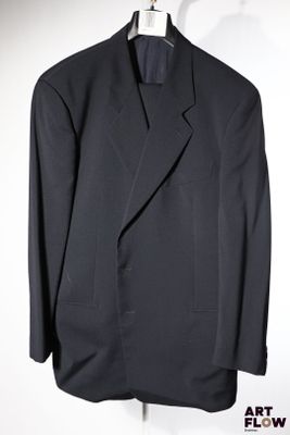 une photo d'un costume noir sur un cintre