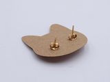 a close up of a pair of earrings on top of a piece of cardboard