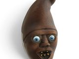 a brown mask with blue eyes on a white wall