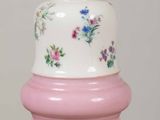 a pink and white vase sitting on top of a wooden table