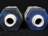 two blue and white vases sitting on a black surface