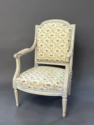 a white chair with a floral upholstered back and arms