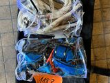 un sac noir rempli d'objets divers, posé par terre