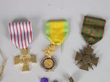 five medals and a pin on a white table