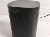 a close up of a black speaker sitting on top of a table