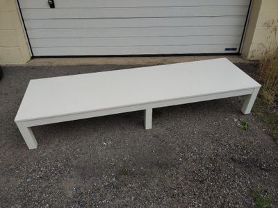 a white bench sitting in front of a garage door