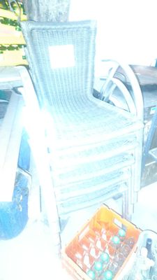une chaise en osier placée à côté d'une table sur laquelle se trouve une boîte