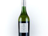 the bottle of white wine is sitting on a white surface
