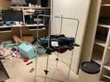a clothes rack in the middle of a cluttered room