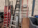de nombreuses échelles empilées dans un garage