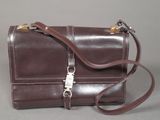 brown leather purse with metal clasps and a strap