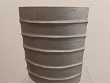 a large gray vase sitting on top of a glass table