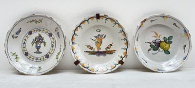 trois assiettes à motifs différents posées sur une surface blanche