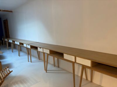 une longue table en bois avec deux chaises dans la pièce