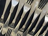 a lot of forks and spoons that are on the table