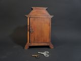 a small wooden cabinet with a door and a key