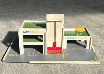 a model of a building with a red chair and a table