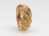 a close up of a gold ring with diamonds on a white background