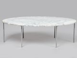 une table basse en marbre blanc aux pieds chromés sur fond gris