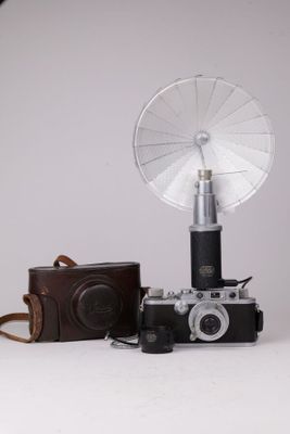 un appareil photo et un petit ventilateur posés sur une table blanche