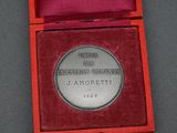a silver medal in a red box on a table