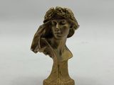 une statue en bronze d'une femme avec un chapeau sur la tête