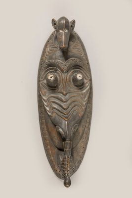 une image représentant une paire de masques en métal accrochés à un mur