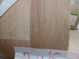 une chaise en bois sur laquelle est accrochée une pancarte, à côté d'une boîte de beignets