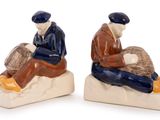 two figurines of two men sitting on a rock