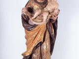 statue of jesus holding a child in his arms on a wooden base
