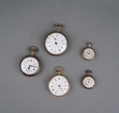 Plusieurs types de montres de poche sont exposés sur un support gris.