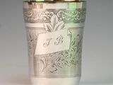 a silver cup sitting on a table with a name tag on it