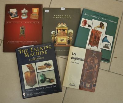 Plusieurs livres sont posés les uns à côté des autres sur un sol carrelé.
