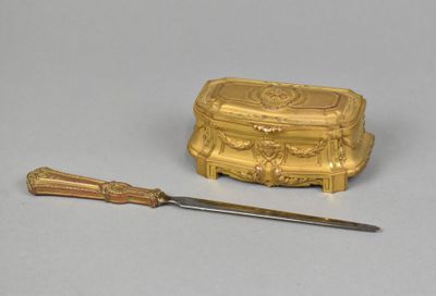 a gold box and a knife on a table