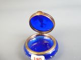 une petite boîte en verre bleu ornée d'un anneau doré